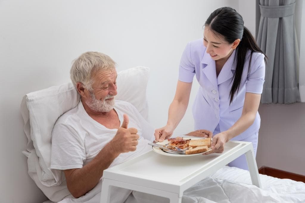 Home health aide assisting a bed-bound patient with safe positioning and personal care