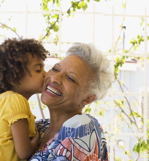 Woman and young girl embracing outdoors